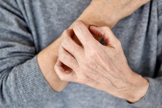 photo of man scratching forearm