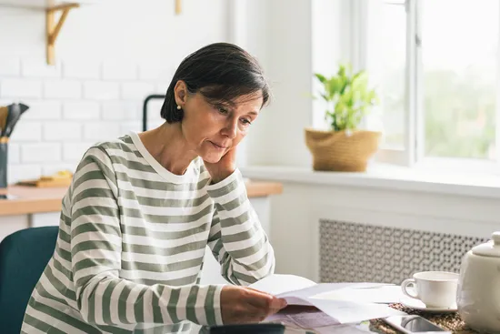 photo of Woman looking at the bills