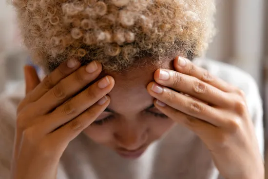 photo of woman with headache rubbing forehead