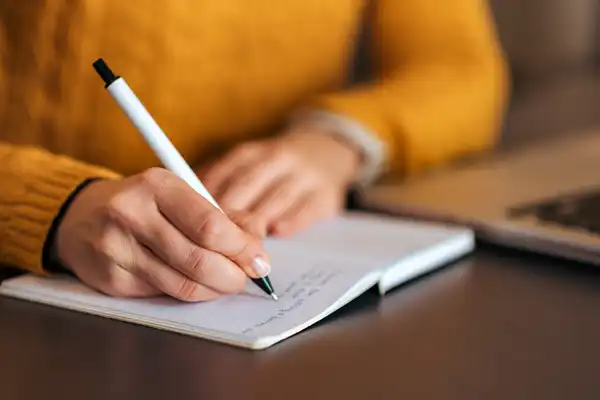 photo of woman writing in journal