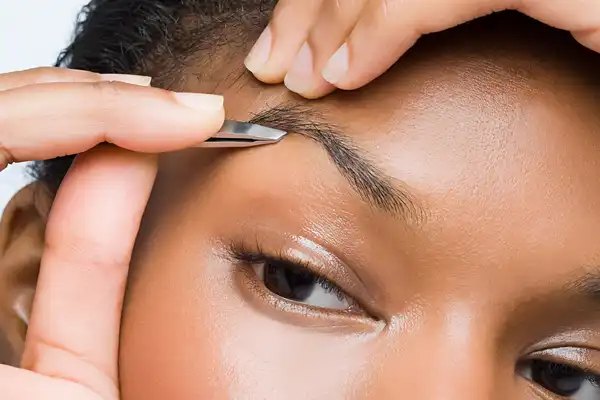 woman plucking eyebrows
