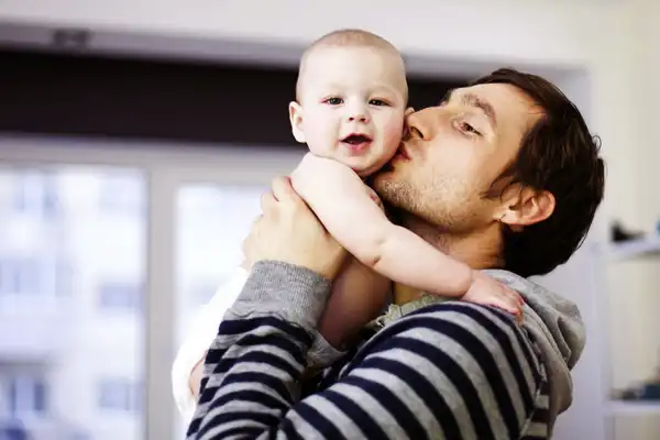 photo of proud father holding baby son