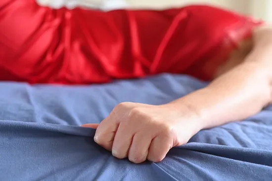 photo of woman experiencing orgasm in bed