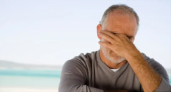 man rubbing eyes
